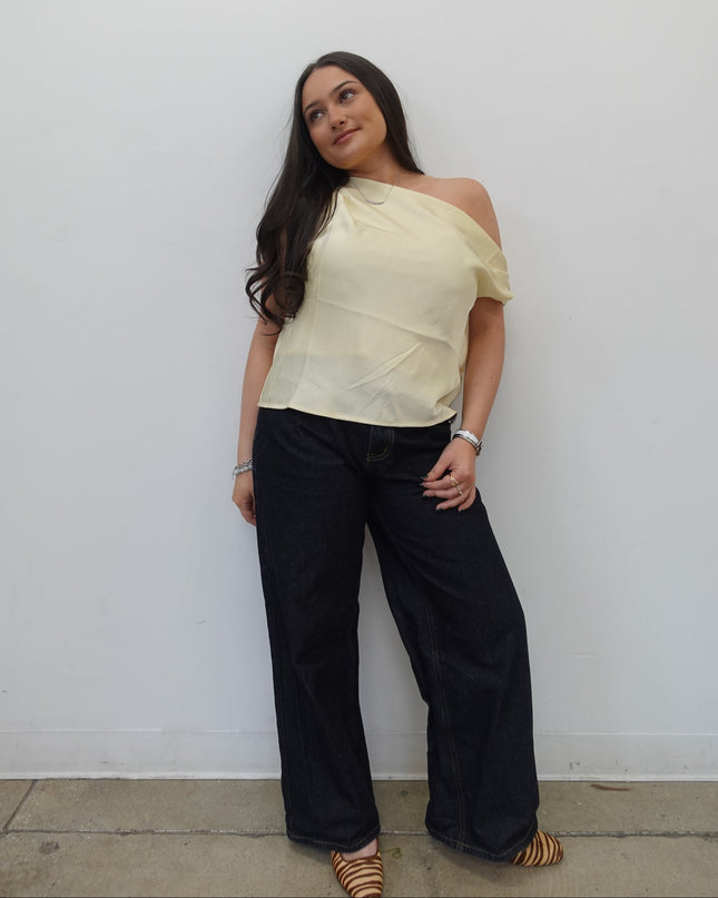 Woman standing on a white floor with a neutral expression